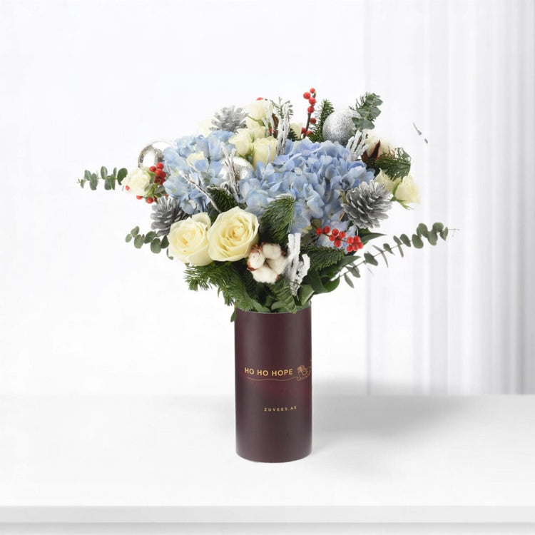 Elegant winter bouquet in burgundy vase with "HO HO HOPE" text.
