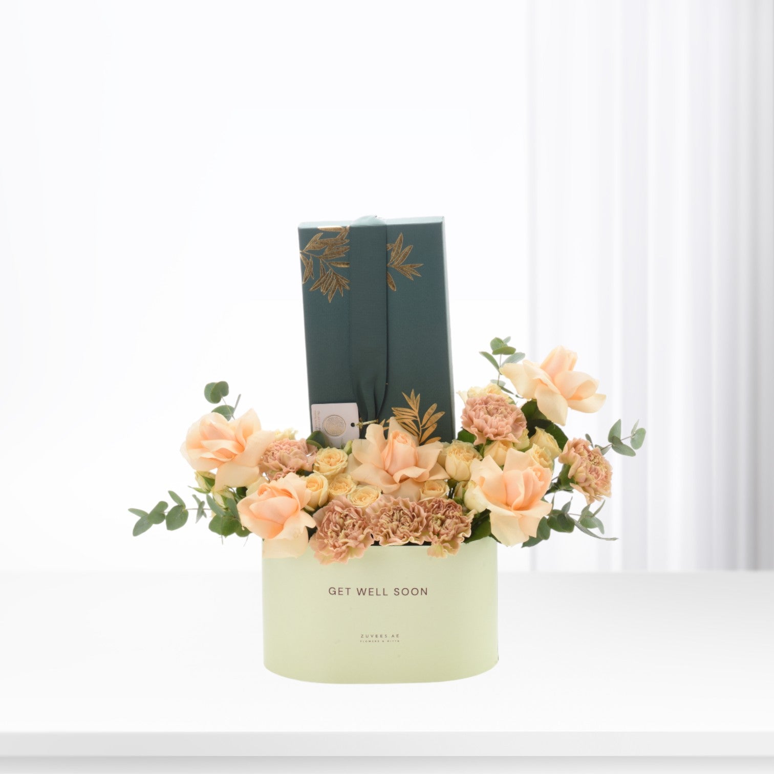 Pastel peach roses and carnations in mint box with "Get Well Soon" message.