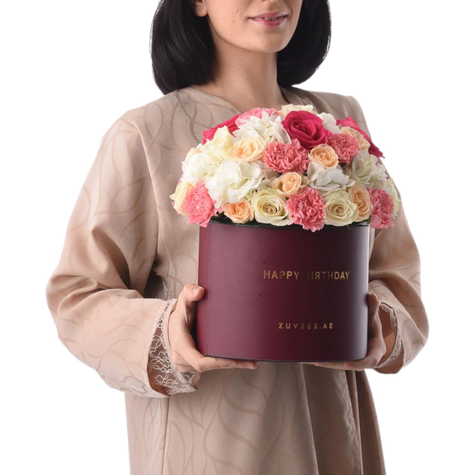 Woman holds burgundy birthday box filled with vibrant pink, peach, and white roses.