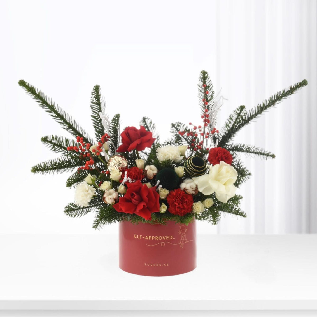 Vibrant red and white floral arrangement in festive red box with "Elf-Approved" text.
