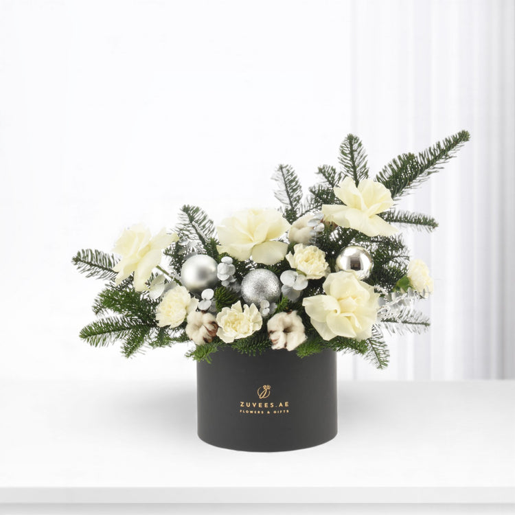 Elegant white floral arrangement with silver ornaments in sleek black box.