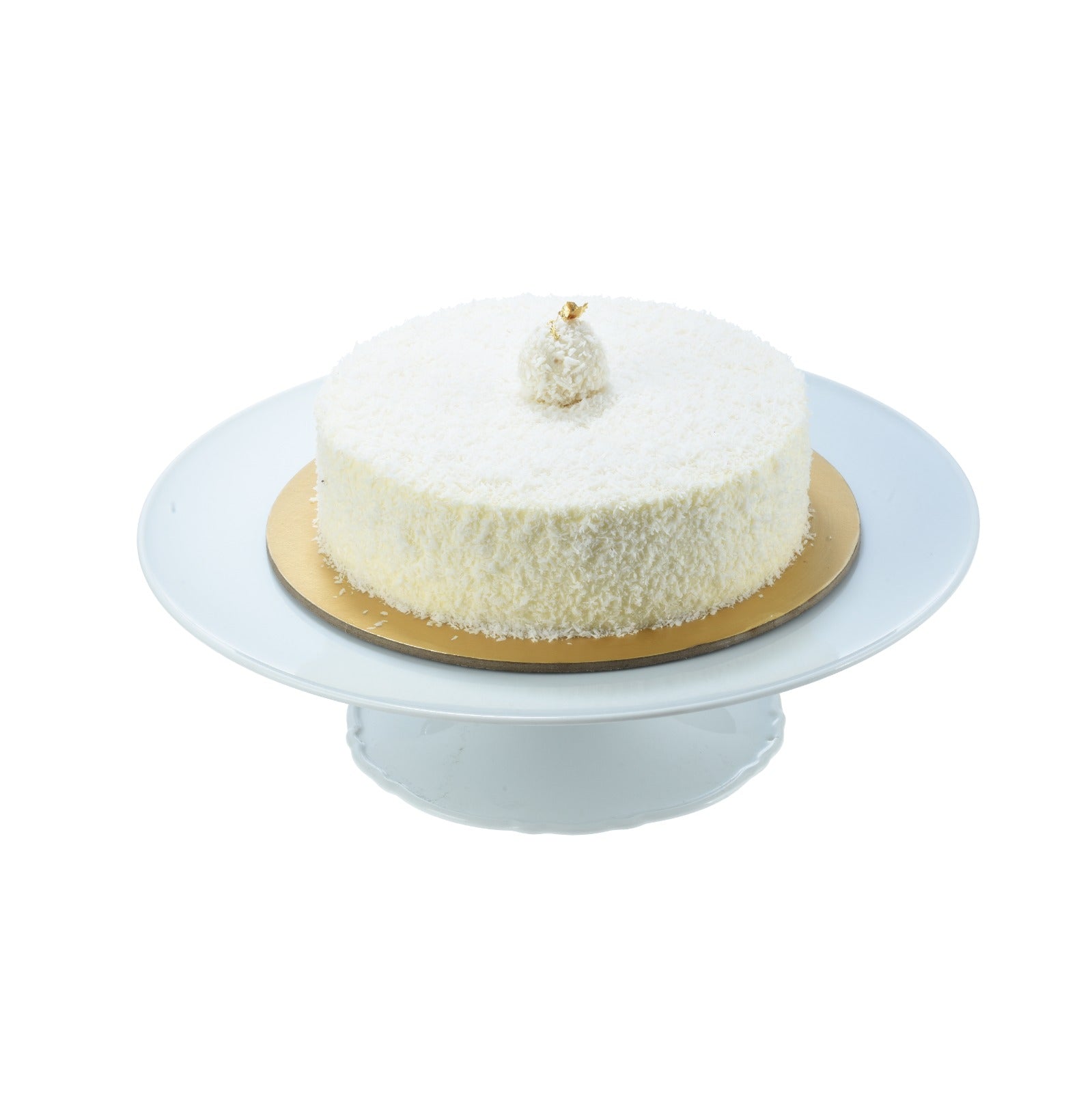 White coconut cake on gold base, topped with gold leaf, elegant presentation.