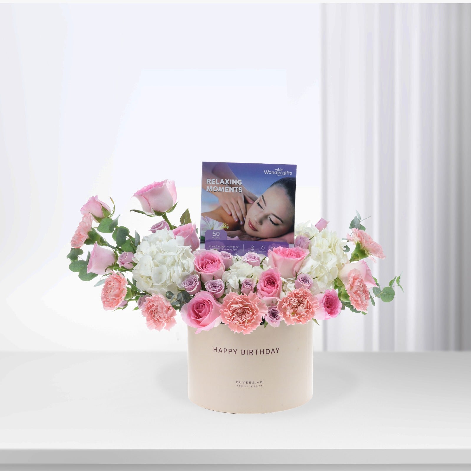 Pastel pink and white floral arrangement in "Happy Birthday" box with massage voucher.