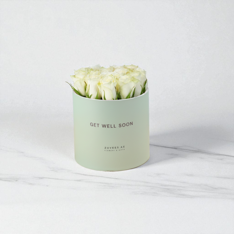 Pastel green box holds creamy white roses, “Get Well Soon” message.