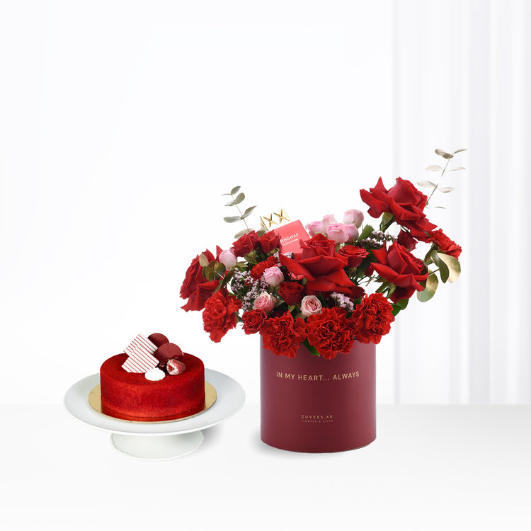 Vibrant red roses and cake in elegant gift box with golden text.