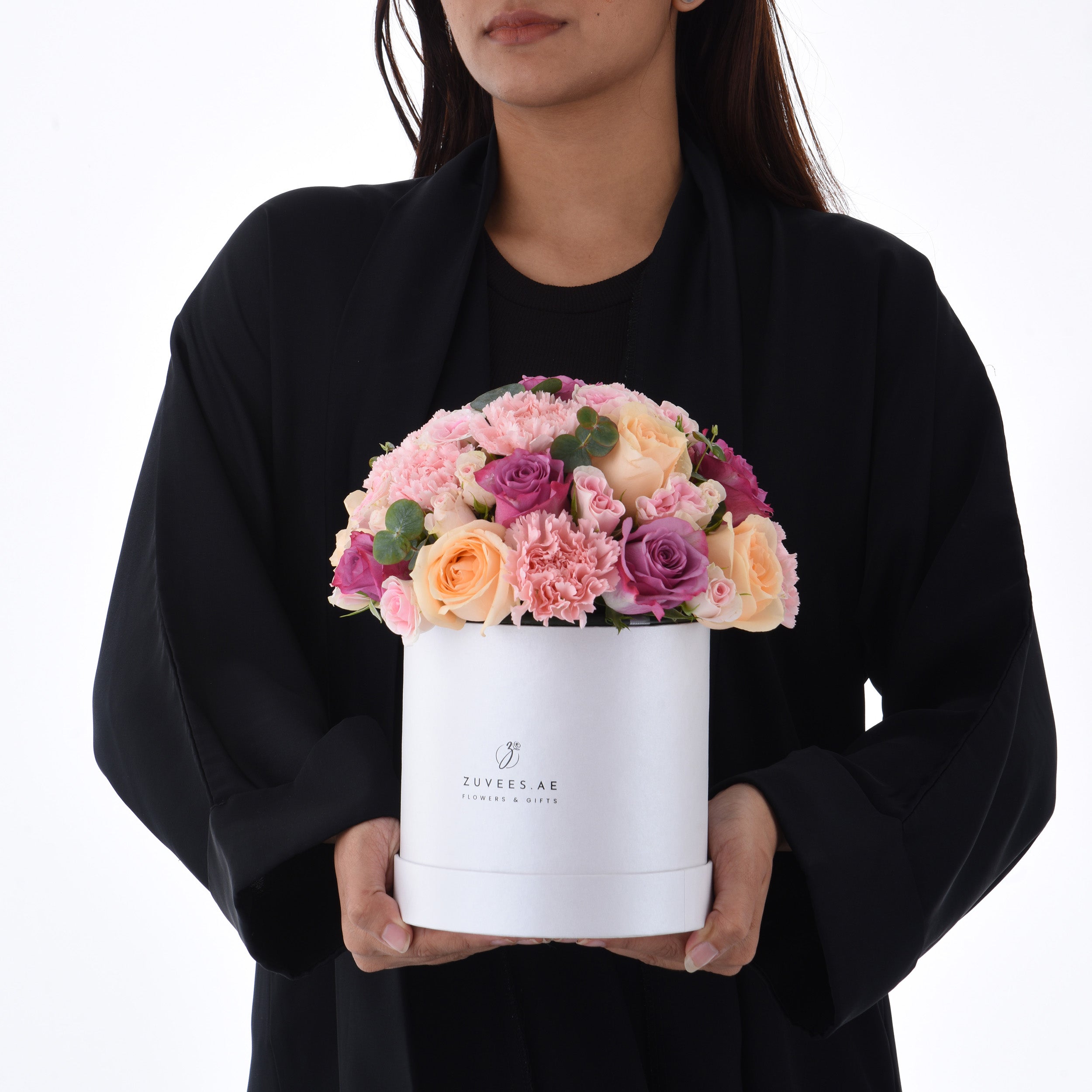 Elegant white hat box filled with pink, peach, and purple roses and carnations.