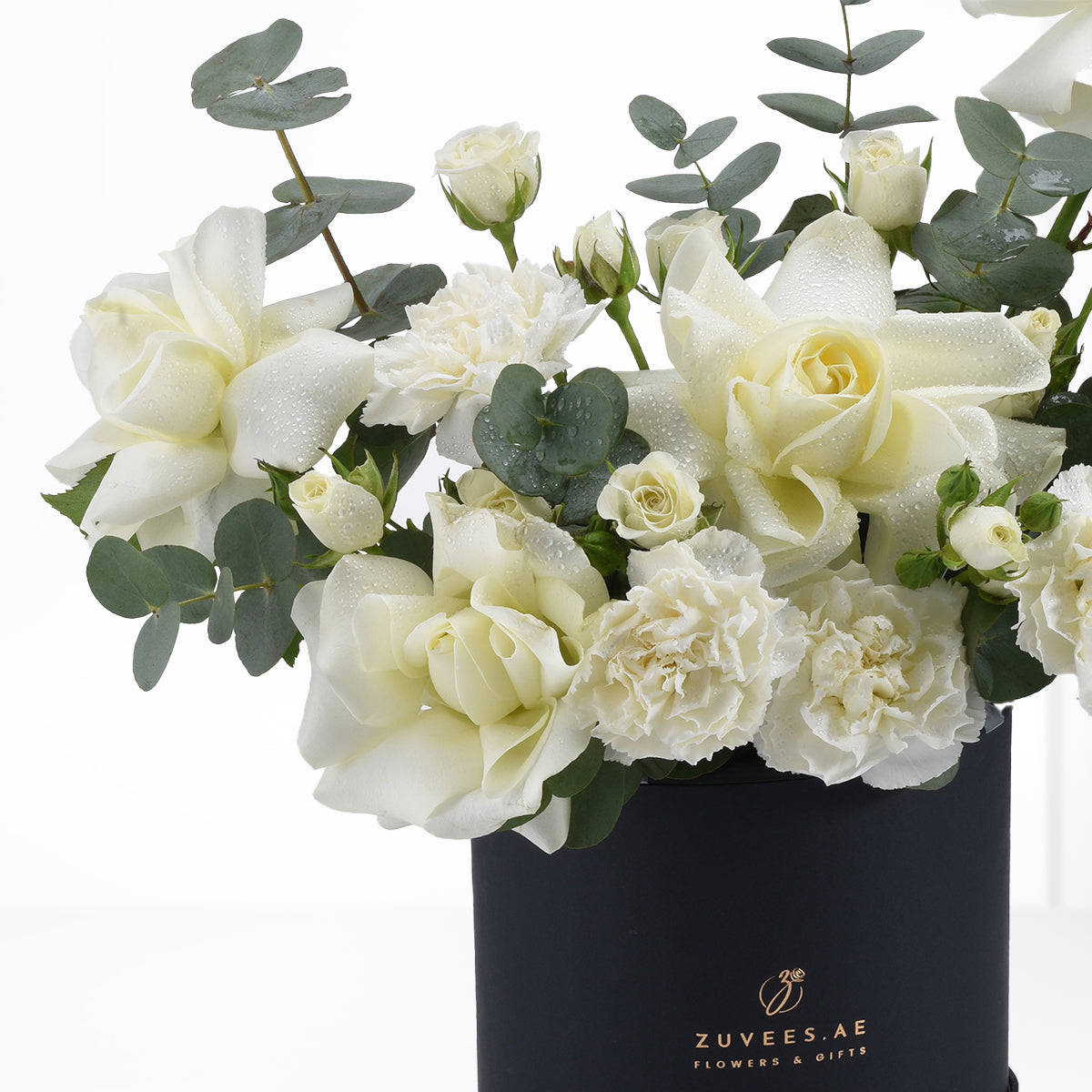 Elegant white roses and carnations with dewdrops in sleek black vase.