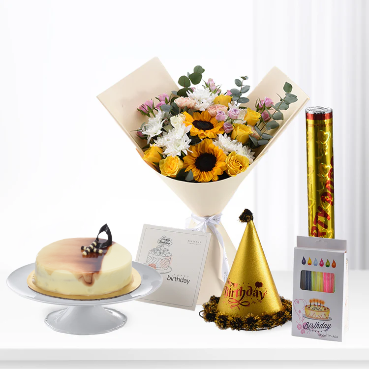 Sunflower bouquet, golden party hat, caramel cake, confetti popper, birthday card on white surface.