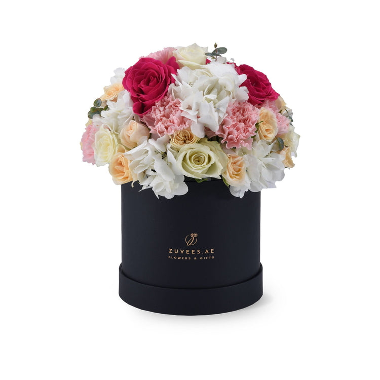 Elegant black box filled with vibrant pink, white, and cream roses and hydrangeas.