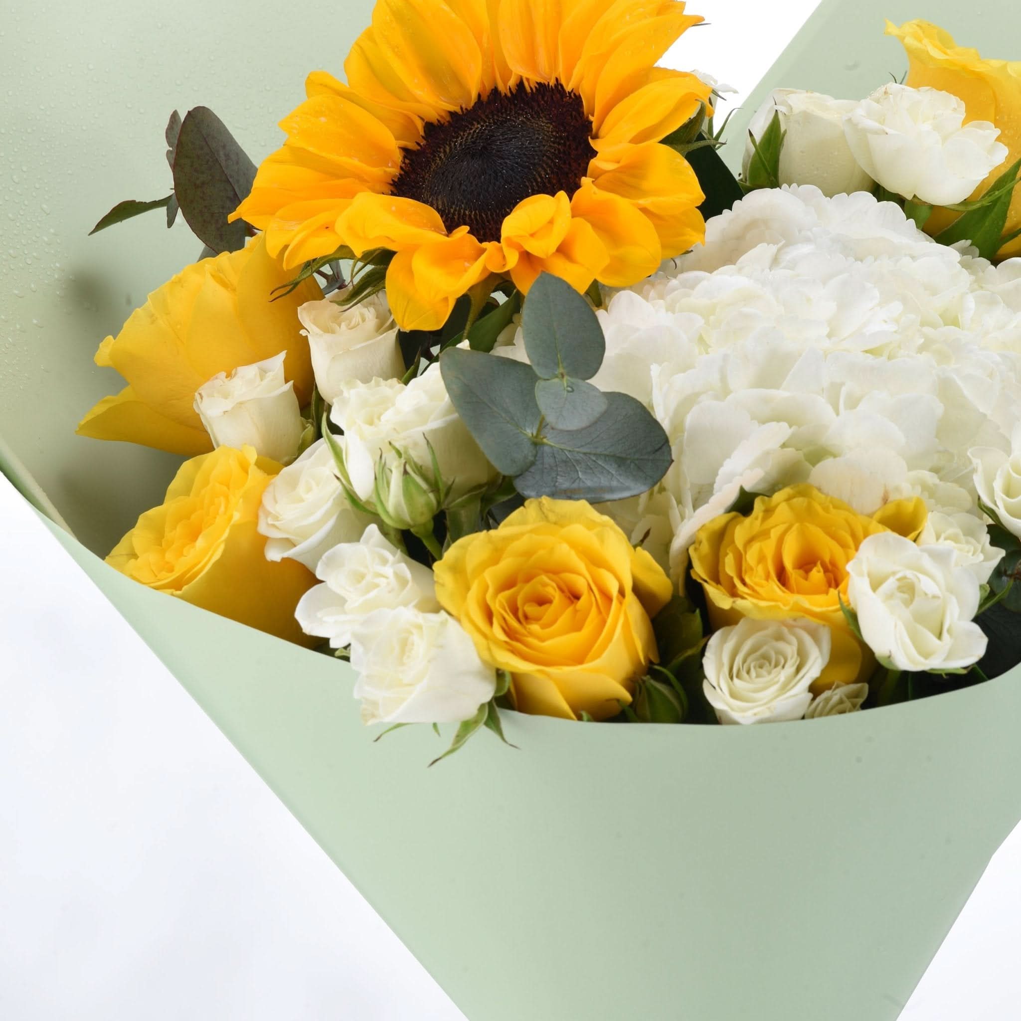 Vibrant sunflower, yellow and white roses, eucalyptus in mint wrap.