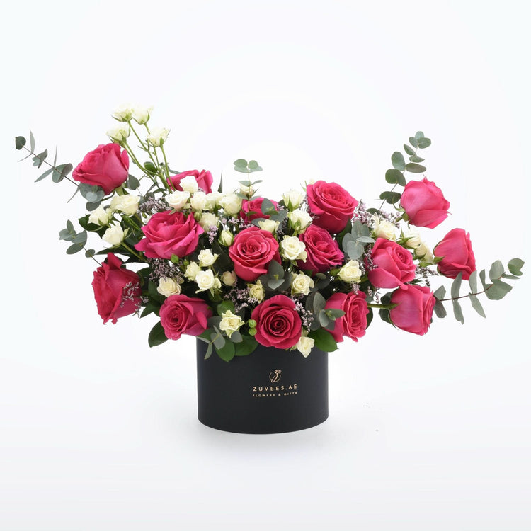 Vibrant pink and white roses in sleek black box with eucalyptus accents.
