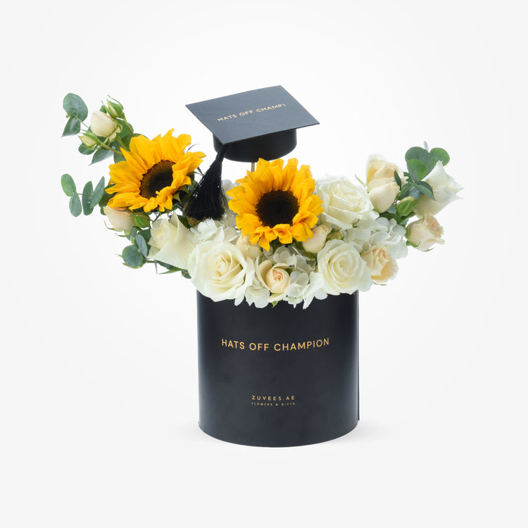 Black "Hats Off Champion" box with sunflowers, white roses, and a graduation cap.