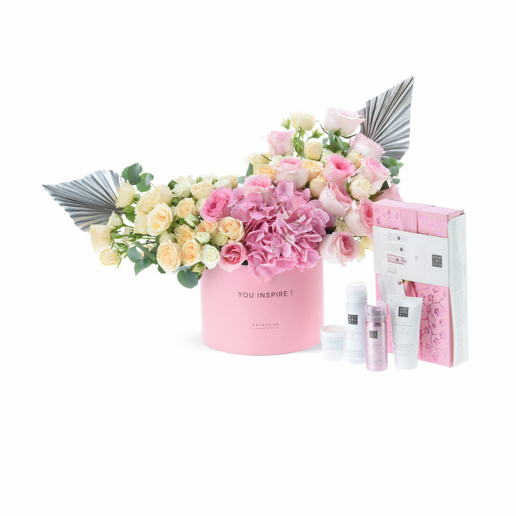 Pink floral arrangement with silver accents and matching skincare set.