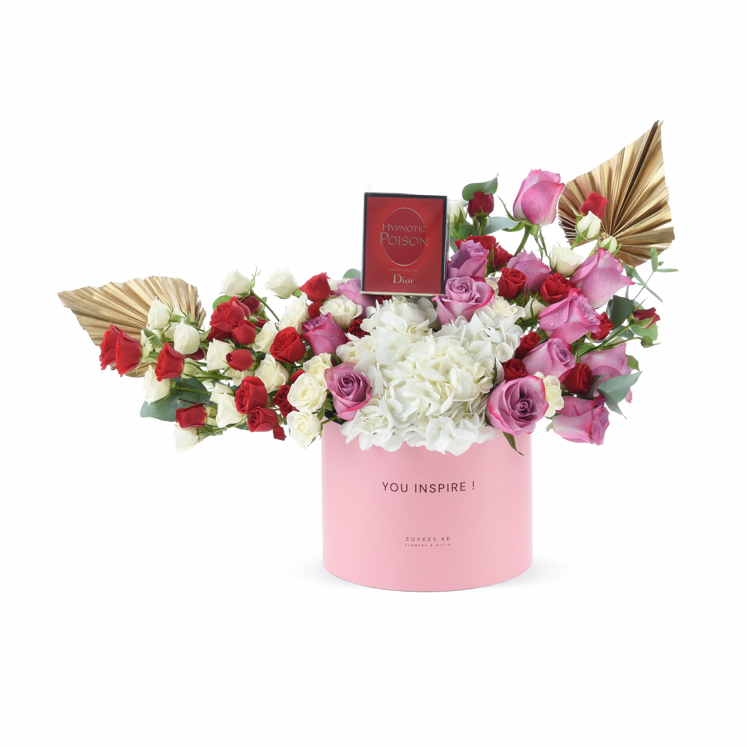 Pink cylinder holds red, white, and pink roses with hydrangeas, gold fans, and Dior perfume.