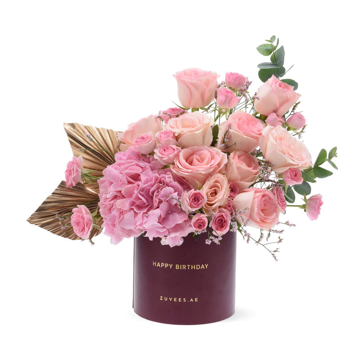 Pink roses and hydrangeas in burgundy box with "Happy Birthday" text.