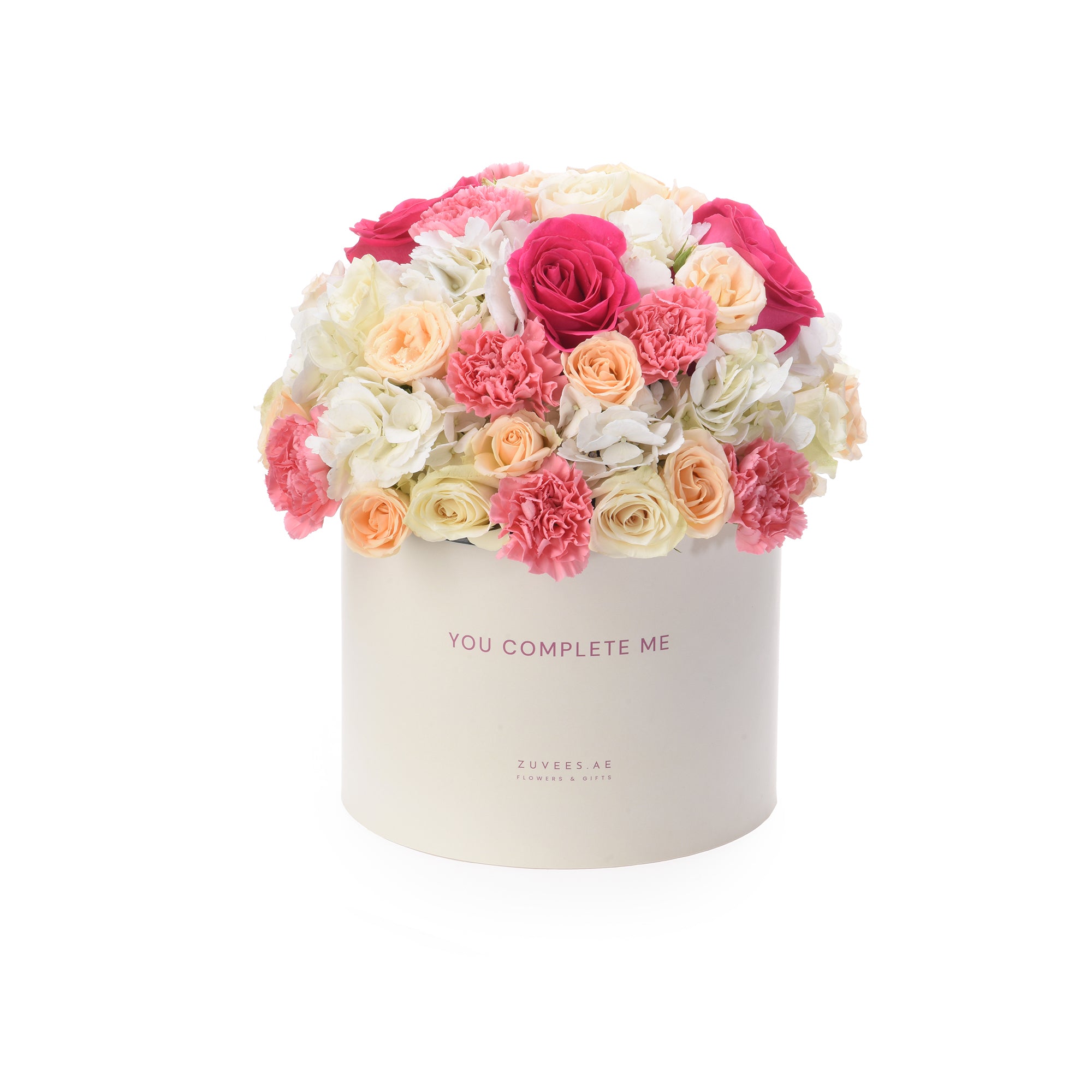 Cream box holds vibrant pink, peach, and white roses and carnations.