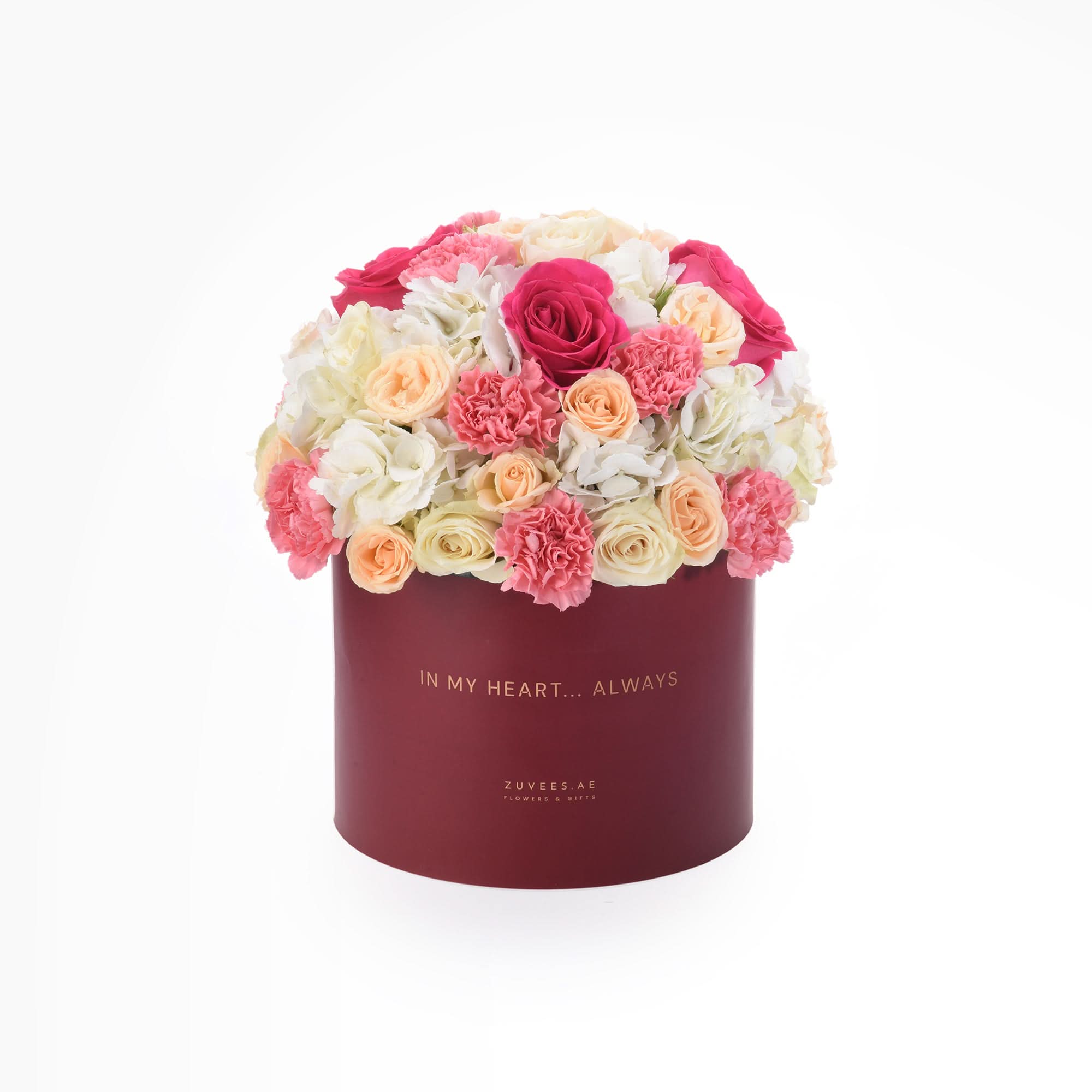 Vibrant pink, peach, and white roses & carnations in burgundy hat box with gold "In My Heart... Always" text.