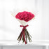 Vibrant fuchsia roses in crisp white paper, tied with burgundy ribbon.