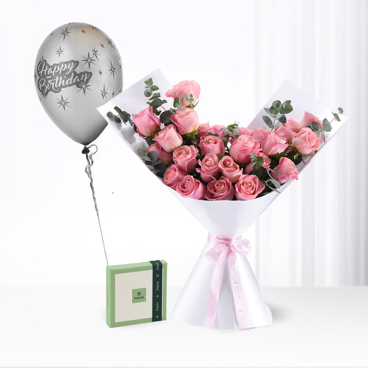 Pink roses bouquet with silver "Happy Birthday" balloon and green gift box.