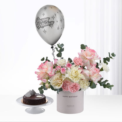 Silver balloon floats above pink-white roses and chocolate cake.