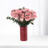 Soft pink roses in red tube vase with gold text, elegant floral gift.