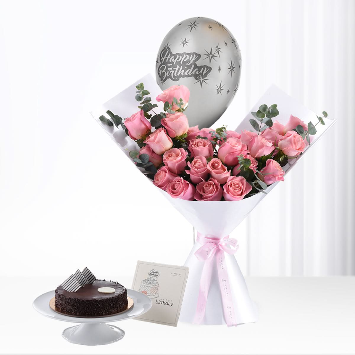 Pink roses, silver balloon, chocolate cake—birthday gift set.