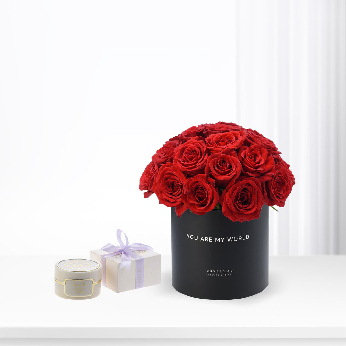 Vibrant red roses in black "You Are My World" box with luxury gift set.