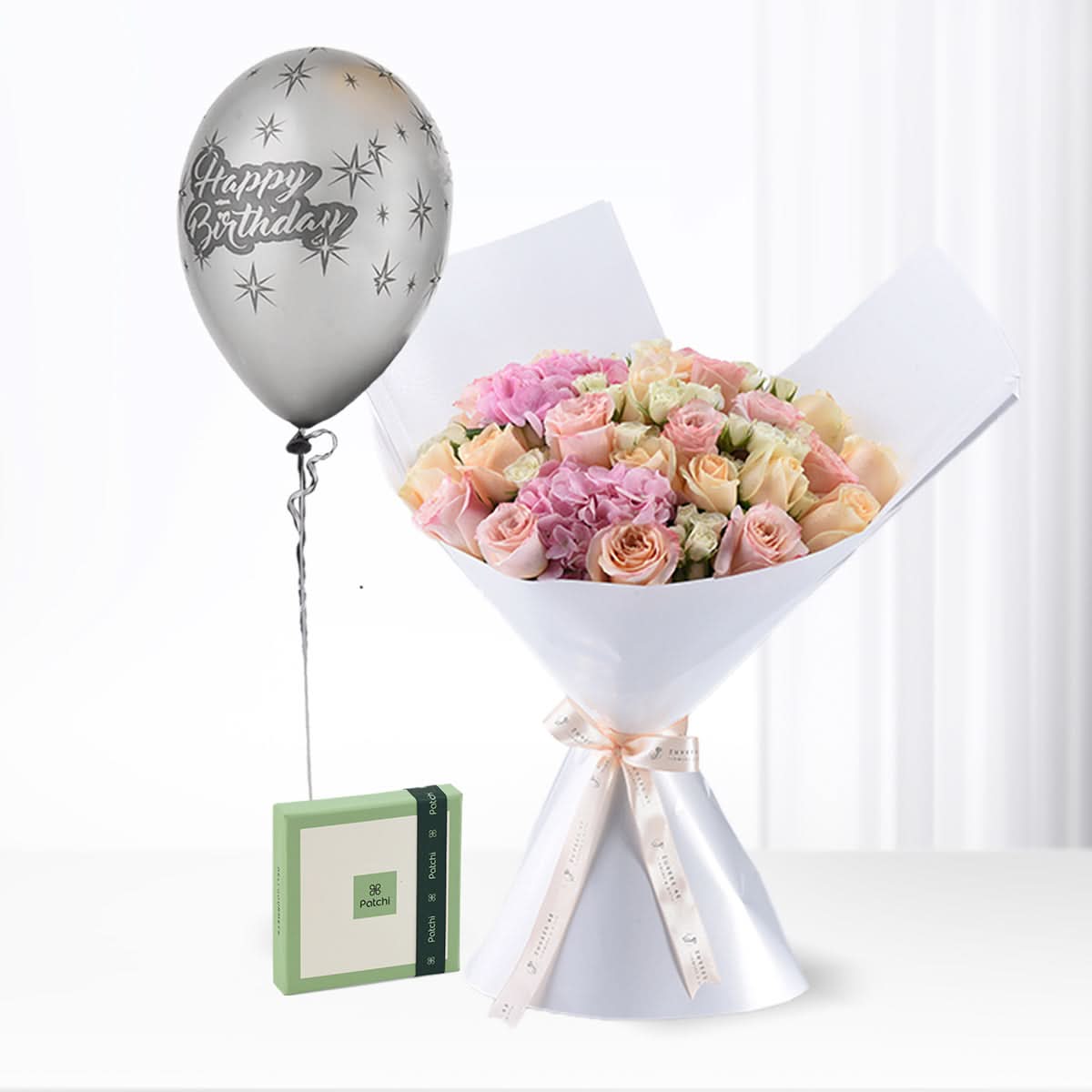 Silver balloon, pastel roses, elegant white wrap, green gift box.