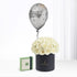 Silver "Happy Birthday" balloon floats above creamy white roses in black cylinder box.
