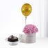 Golden "Happy Birthday" balloon atop pink hydrangeas, beside chocolate cake.