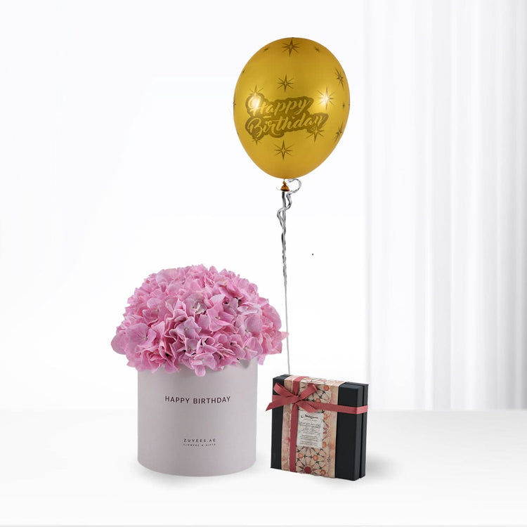 Pink hydrangeas in grey box, gold "Happy Birthday" balloon, elegant gift box.