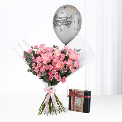 Pink roses bouquet with silver "Happy Birthday" balloon and chocolate gift box.