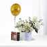 Golden balloon, white roses, and gift box celebrate birthday elegantly.