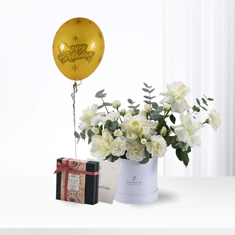 Golden balloon, white roses, and gift box celebrate birthday elegantly.