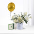 Golden balloon, white roses, greenery, and Patchi chocolates in elegant birthday gift arrangement.
