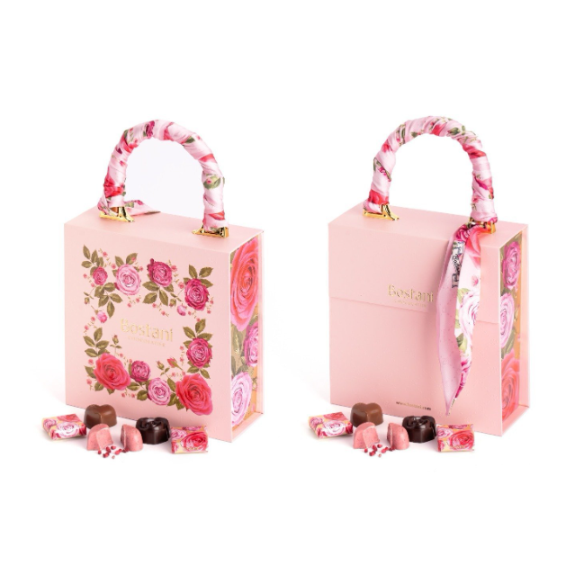 Pink floral gift boxes with silk handles, luxury chocolates displayed.