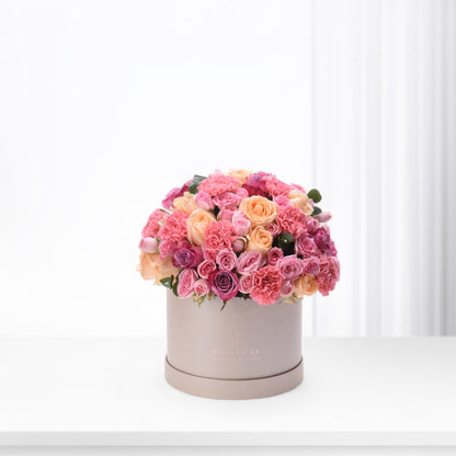 Pink and peach roses and carnations in matte taupe hat box.