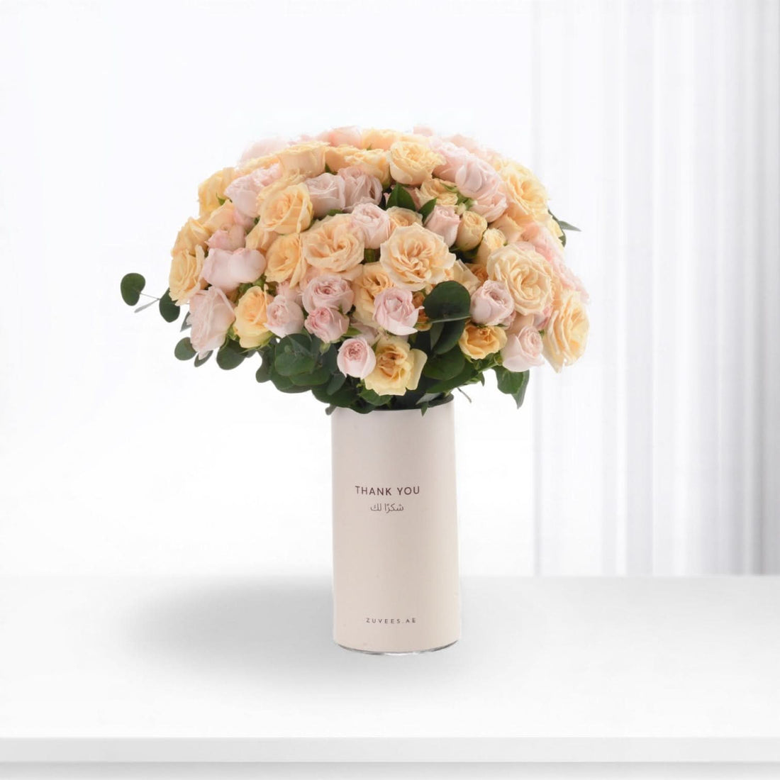 Pastel peach roses in minimalist vase with "Thank You" text.