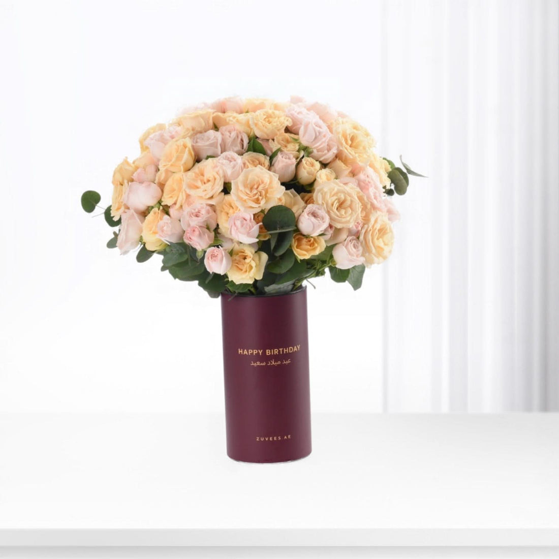 Pastel peach roses in burgundy tube vase with "Happy Birthday" text.