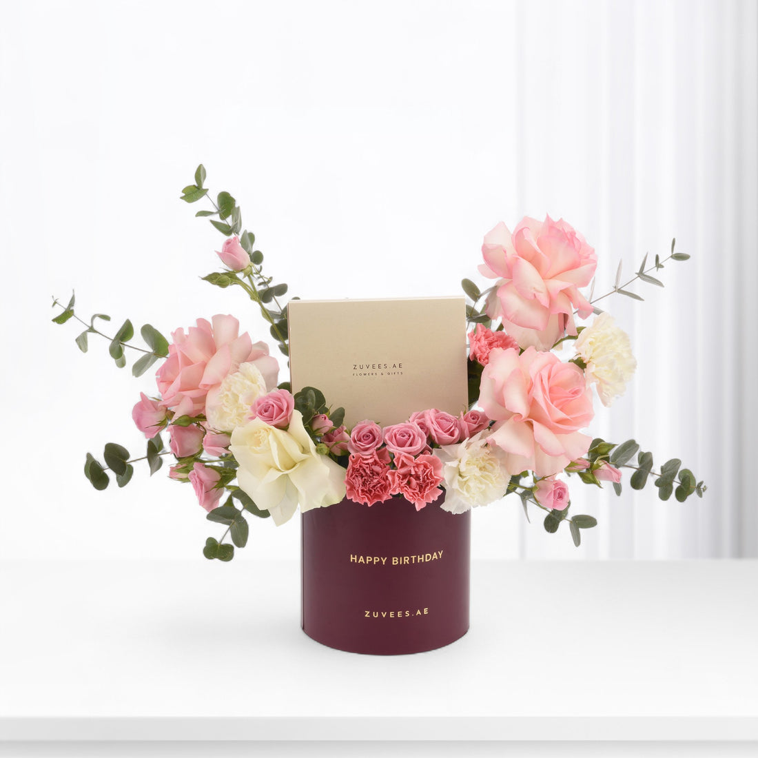 Elegant burgundy birthday floral arrangement with pink roses, carnations, and eucalyptus.