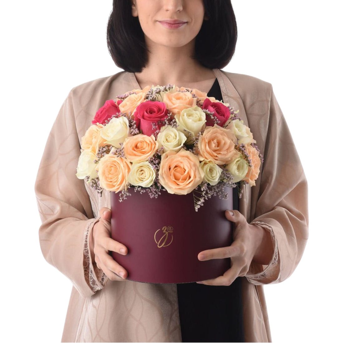 Woman holds burgundy hat box filled with vibrant multi-colored roses.