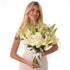 Woman holds elegant white lily and hydrangea bouquet in clear vase.