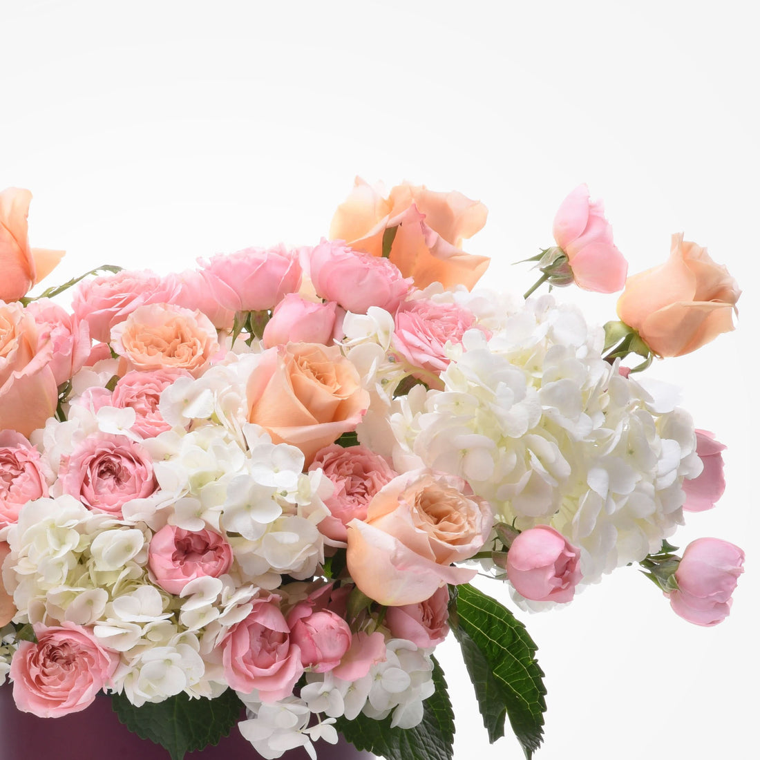 Soft peach roses and white hydrangeas in lush, romantic bouquet.