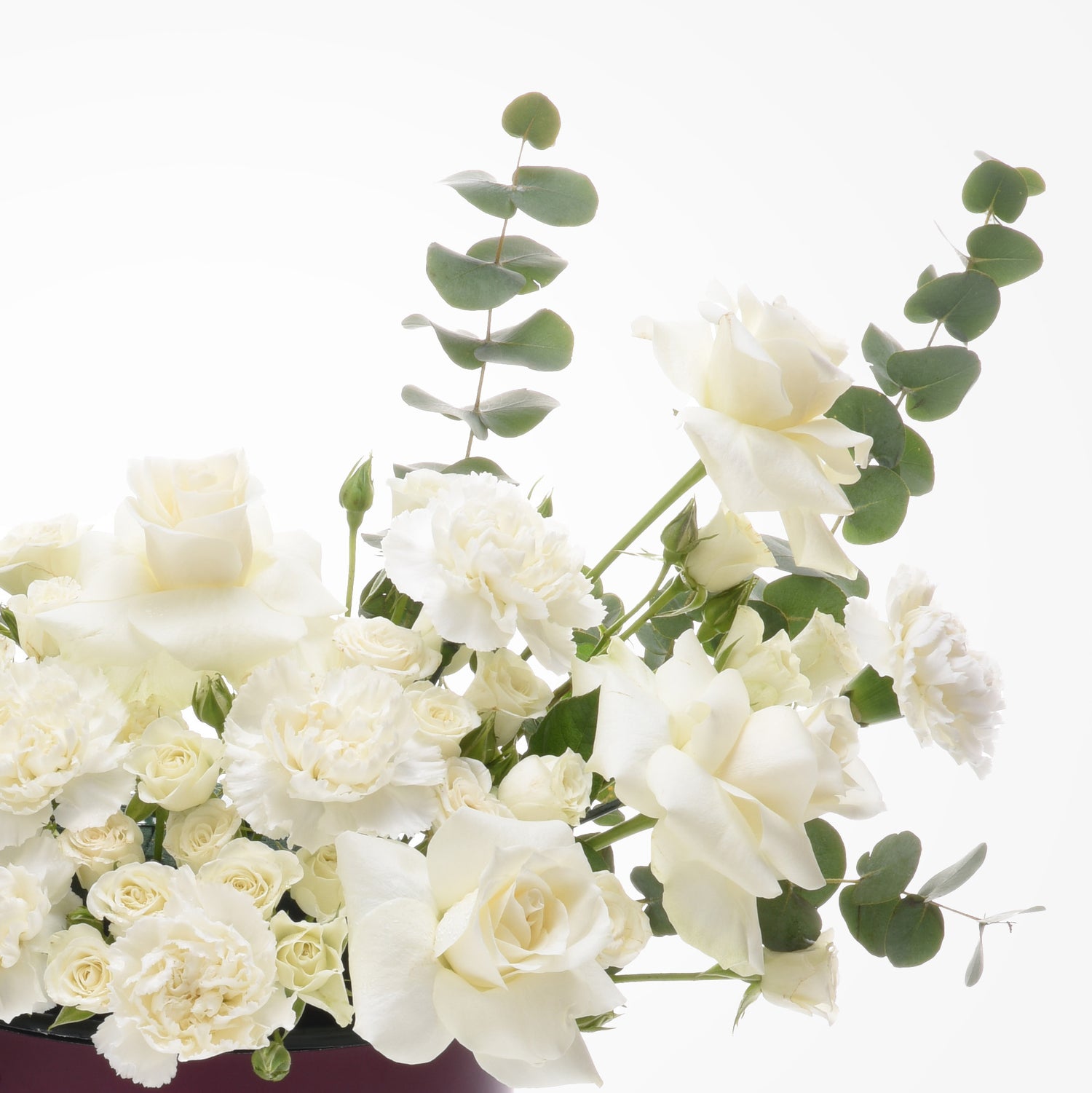 Elegant white roses and eucalyptus in minimalist floral arrangement.