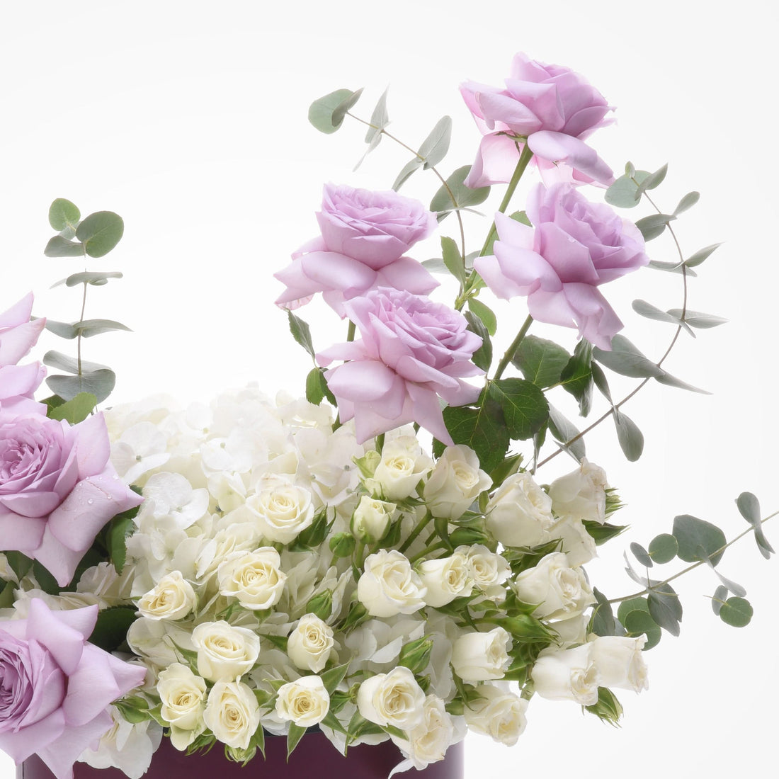 Soft lavender and ivory roses with eucalyptus, elegant floral arrangement.