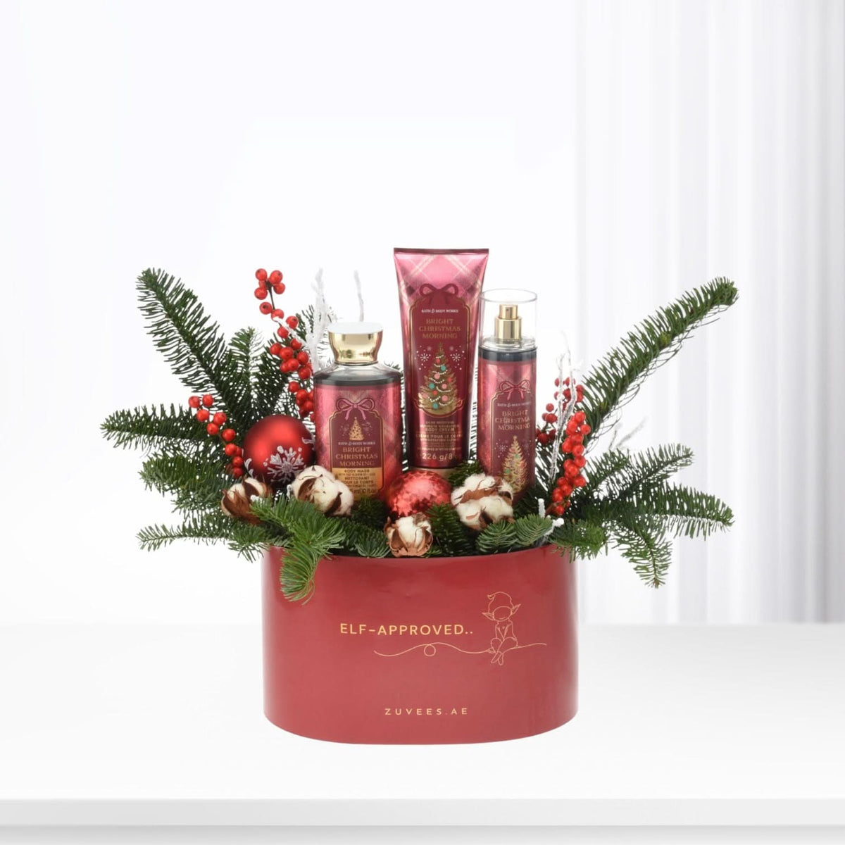 Red holiday gift basket with festive greenery, berries, and Bath &amp; Body Works products.