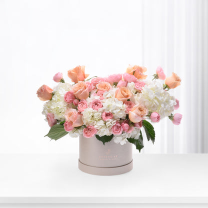 Soft pink roses and white hydrangeas in elegant taupe box.