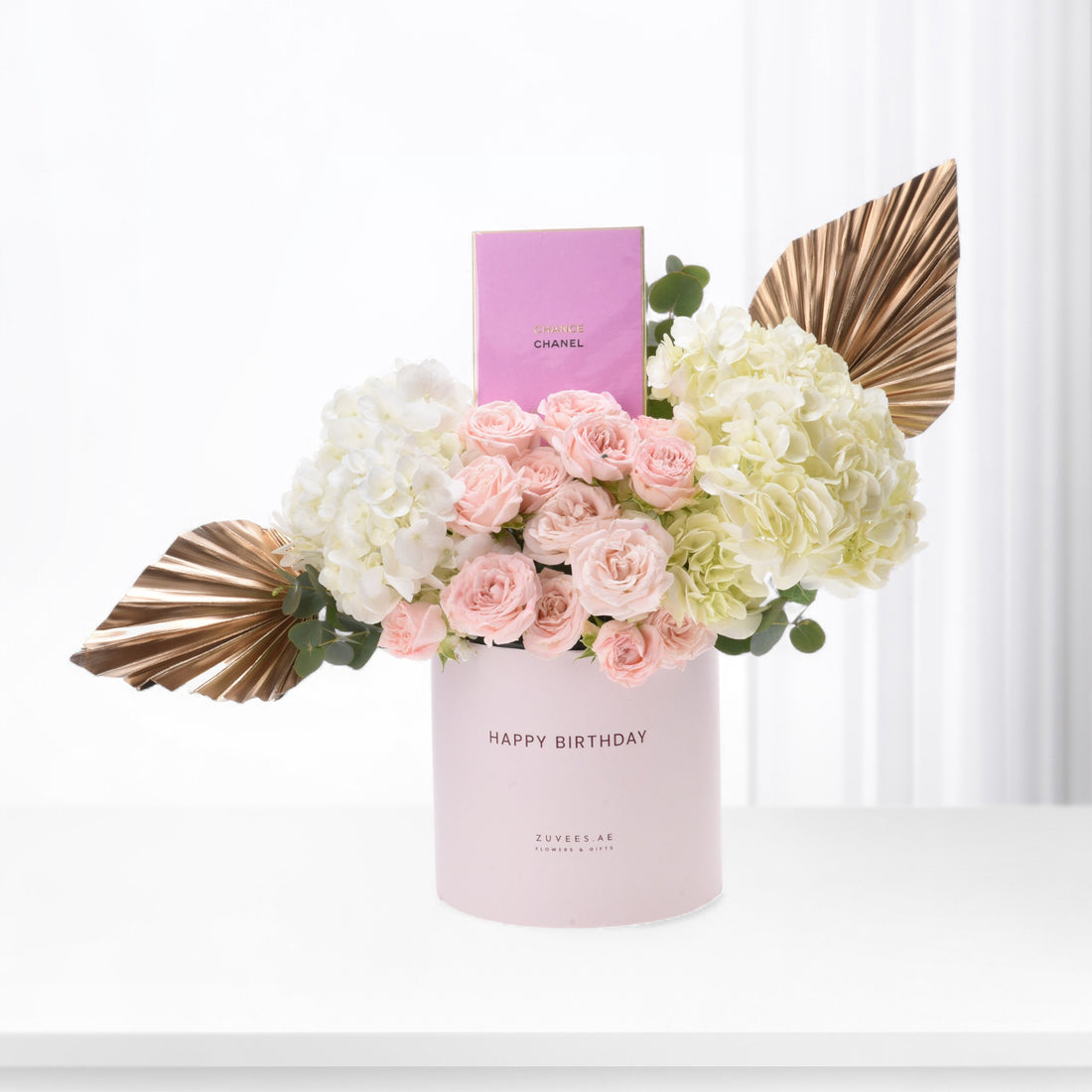 Pink roses, white hydrangeas, gold leaves in blush “Happy Birthday” box with Chanel card.