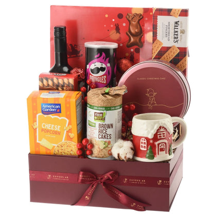 Festive gift basket with wine, snacks, mug, and red ribbon, perfect for holiday gifting.
