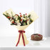 Festive white rose bouquet with gold ornaments, red berries, pinecones, beside chocolate log cake.